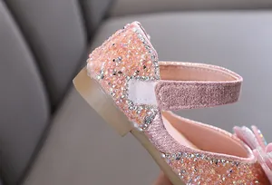 Detalle de primer plano de zapatos de princesa rosa con purpurina y pedrería para niña