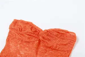 Close-up detail of an orange floral lace tube top with elegant pleated chest design.