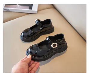 Close-up of black patent leather girls' Mary Jane shoes with pearl buckle detail