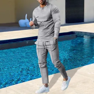 Model wearing gray long-sleeved shirt and trousers by a pool, showing the casual fit