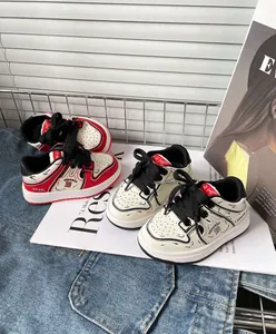 Dettaglio di scarpe da ginnastica stile cartone animato per neonati su denim