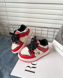 Dettaglio ravvicinato di sneaker per bambini con design unico manga line art rosso e bianco.