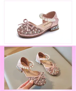 Close-up detail of pink glitter princess sandals with pearl strap and rhinestone bow