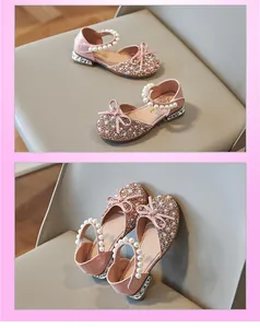 Close-up of pink glittery girls princess shoes with pearl straps and bow details