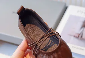 Primer plano del interior y las correas cruzadas de los zapatos de princesa de cuero marrón.