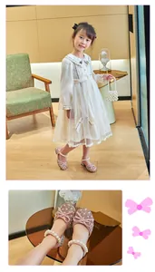 Close-up of pink glitter sandals with pearl ankle straps and decorative bows for girls