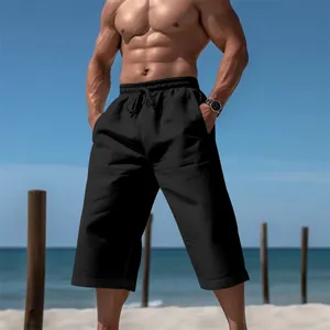 Detail van een ademende zwarte vrijetijdsbroek voor heren op het witte zomerse strand