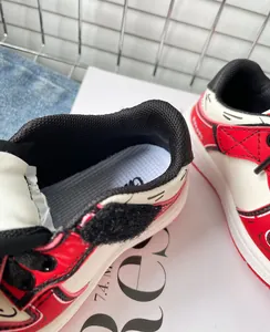 Dettaglio ravvicinato di scarpe sportive per bambini rosse e bianche con velcro
