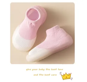 Detalle de zapatos tipo calcetín para bebé en rosa y blanco con suelas antideslizantes