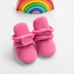 Patucos de forro polar rosa para bebé con correas ajustables para mayor comodidad.