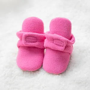 Vista detallada de zapatos para bebé de forro polar rosa con cierre de velcro ajustable