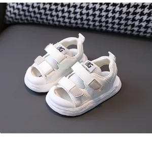 Detailed macro view of white closed-toe baby sandals with mesh and velcro straps.