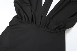 Close-up detail of the pleated waist and deep V-neck on a slim-fit black dress.