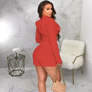 Sexy red long sleeve romper with pocket detail, side view on model in a glam room.