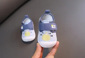 Close-up detail of blue cartoon squeaky baby shoes featuring a cute cat embroidery.