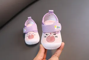 Detail of pink cartoon infant walking shoes with cute bunny embroidery and velcro strap