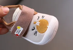 Close-up of baby squeaky walking shoes with cute cartoon embroidery and strap