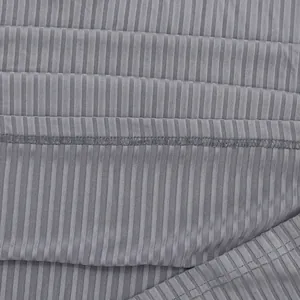 Gedetailleerde macro-opname van de grijze geribbelde stoftextuur en stiksels op een poloshirt