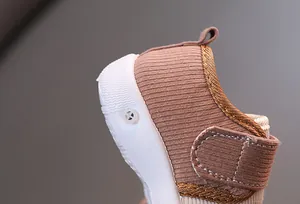 Close-up of a baby walking shoe showing the ribbed fabric and white rubber sole detail