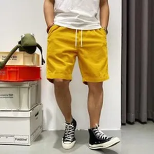 Close-up detail of yellow corduroy shorts with adjustable white drawstring for men