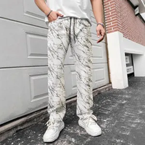 Detail view of men's casual long pants featuring a stylish white and black marble print pattern