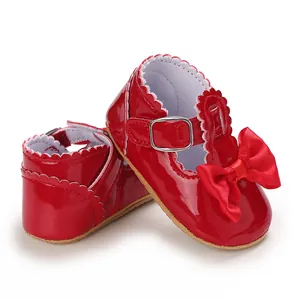 Detailansicht von eleganten roten Lackleder-Babyschuhen mit dekorativer Schleife