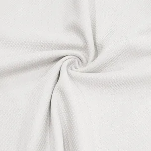 Dettaglio macro della trama del tessuto a nido d'ape bianco per set polo estivo da uomo
