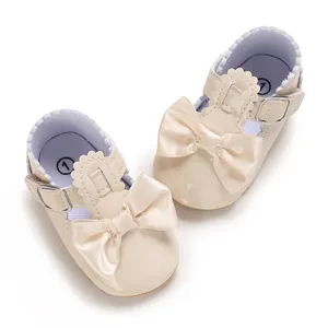 Detail von cremefarbenen Lauflernschuhen für Mädchen mit großer Schleife