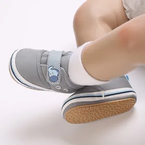 Primo piano di scarpe primi passi grigie per neonati con suola morbida e velcro