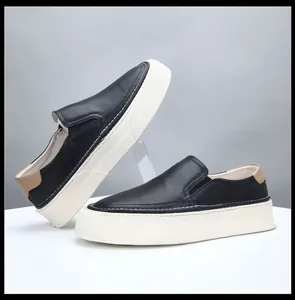 Detailed side view of black leather platform loafers with thick white soles.