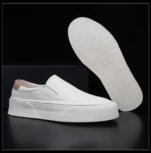 Detailed view of white cowhide leather slip-on loafers featuring a thick textured rubber sole