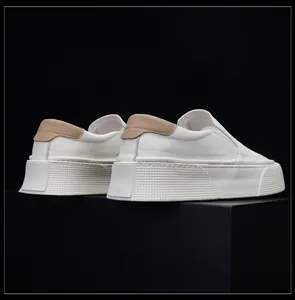 Rear view of white leather slip-on loafers with thick textured soles and tan heel details