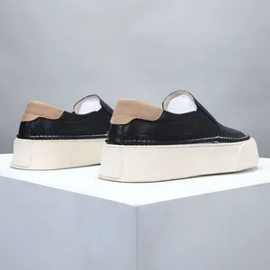 Men's soft black leather slip-on loafers with thick cream sole and tan heel detail