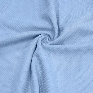 Dettaglio ravvicinato del tessuto azzurro a nido d'ape con texture traspirante