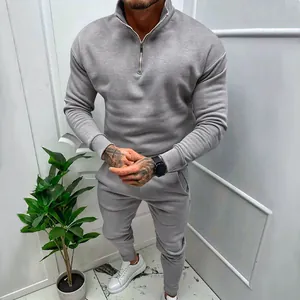Full body view of men's solid grey fleece tracksuit set featuring a quarter-zip sweatshirt and pants