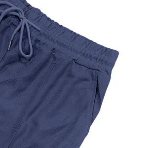Dettaglio dei pantaloncini da spiaggia blu da uomo con coulisse in vita e tessuto testurizzato