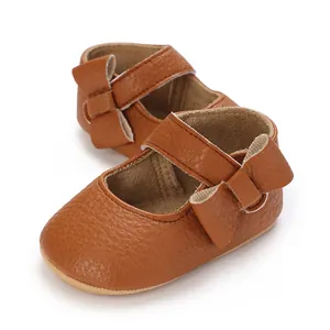 Macro view of brown faux leather baby Mary Jane shoes with cute bow detail and soft sole