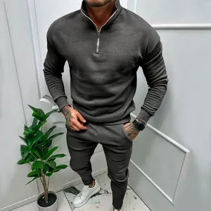 Close-up view of a premium men's dark grey half-zip fleece tracksuit set with joggers