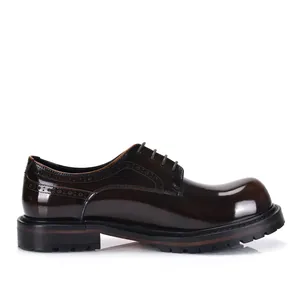 Vista lateral de zapatos Derby de cuero brillante marrón con puntera redonda y brogue