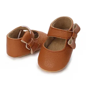 Detailed view of brown faux leather baby walking shoes with cute bow decoration and soft sole