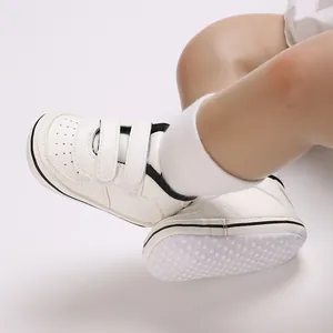 Detailed close-up of white baby walker shoes with non-slip soles and Velcro straps