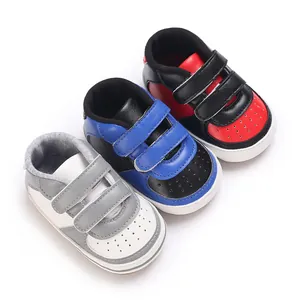 Vue rapprochée de baskets pour bébé colorées en noir-rouge, noir-bleu et blanc-gris.