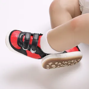 Vue détaillée de baskets pour bébé rouge et noir avec semelle antidérapante à motifs
