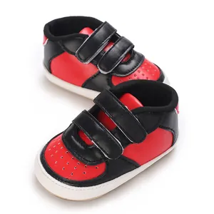 Vue détaillée des baskets bébé rouges et noires avec doubles brides auto-agrippantes.