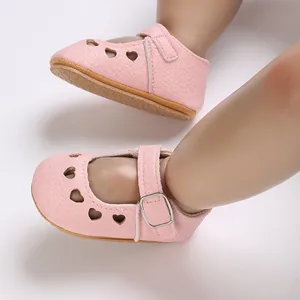 Close-up of pink baby soft sole non-slip shoes with heart cutouts for infants.