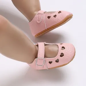 Detailed view of pink baby shoes featuring heart cutouts and non-slip silicone soles.