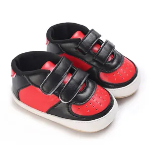 Vue détaillée des baskets pour bébé rouges et noires avec double fermeture à scratch