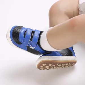 Gros plan de chaussures de sport pour bébé bicolores bleu et noir à semelles souples