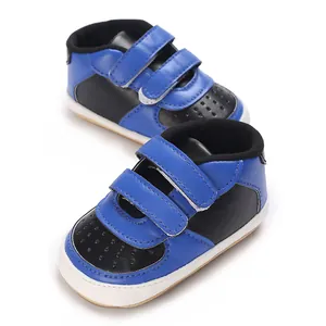 Vue détaillée des baskets pour bébé bicolores bleues et noires avec attaches velcro.