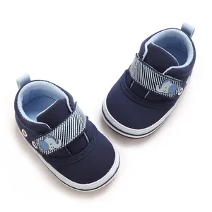 Vista dall'alto di scarpe primi passi per neonati in tela blu navy con simpatico velcro a elefante.